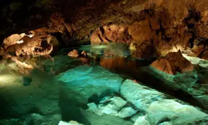 Wnętrze jaskini z turkusową wodą i skalnymi formacjami. Bozkowskie jaskinie dolomitowe zachwycają podziemnym krajobrazem.