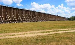 Długie tężnie solankowe, jedna z głównych atrakcji Ciechocinka, na tle błękitnego nieba z chmurami.