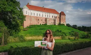 Kobieta trzyma szkic zamku, który przypomina miasto Ojca Mateusza.