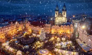 Tłoczny jarmark bożonarodzeniowy w Pradze, z oświetloną choinką i kościołem w tle, to jeden z najpiękniejszych jarmarków bożonarodzeniowych w Europie.