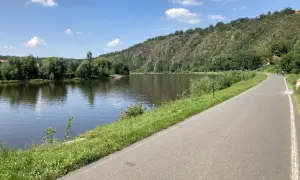 Malownicza ścieżka rowerowa w Czechach wzdłuż rzeki, zalesione wzgórza w tle. Idealne miejsce na aktywny wypoczynek.