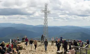 Tarnica: ile się wchodzi? Grupa turystów na szczycie, pod krzyżem, podziwia piękne widoki Bieszczadów.