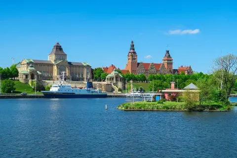 Widok na Odrę z imponującymi budynkami i statkiem. Odkryj atrakcje Szczecin i okolice!