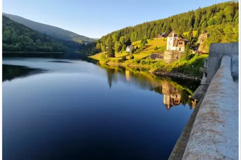 Malowniczy widok na zalew i zamek, idealne szpindlerowy młyn atrakcje. Odbicie zamku w spokojnej tafli wody.