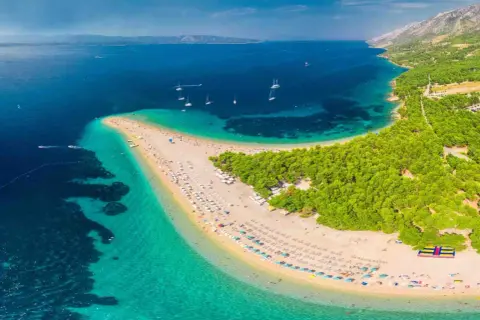 Zlatni Rat, jedna z najpiękniejszych plaż Europy, z turkusową wodą i sosnowym lasem.
