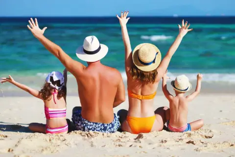 Rodzina wita słońce na plaży. Może to być urokliwa duńska wyspa na Bałtyku, gdzie dzieci rzucają piasek, a rodzice cieszą się wakacjami.