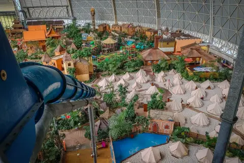 Wielki basen Tropical Island w Berlinie, z tropikalną wioską, zjeżdżalniami i namiotami na piasku.