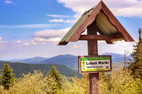 Tablica informacyjna na szlaku Luboń Wielki (1022 m n.p.m.) w Beskidzie Wyspowym. Piękny widok na góry i niebo.