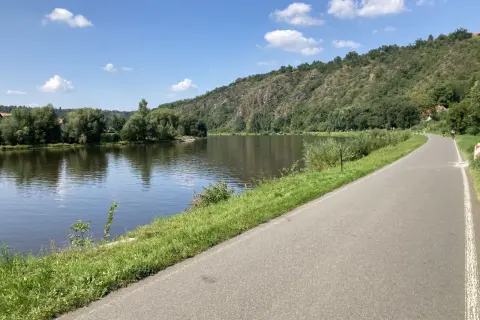 Malownicza ścieżka rowerowa w Czechach wzdłuż rzeki, zalesione wzgórza w tle. Idealne miejsce na aktywny wypoczynek.
