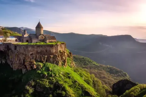 Klasztor Tatew na skale, jeden z cudów, które warto zobaczyć w Armenii. Majestatyczna budowla na tle doliny i zachodzącego słońca.