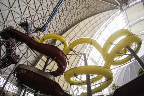 Wodne szaleństwo na tropical island zjeżdżalnie! Kręte, żółte i brązowe rury zapraszają do zabawy pod ogromnym, przeszklonym dachem.