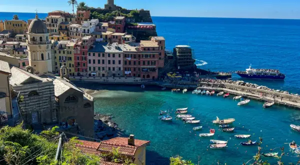Kolorowe domy Vernazzy nad turkusowym morzem, łodzie w zatoce i wieża na klifie – to kwintesencja tego, co warto zobaczyć w Ligurii.