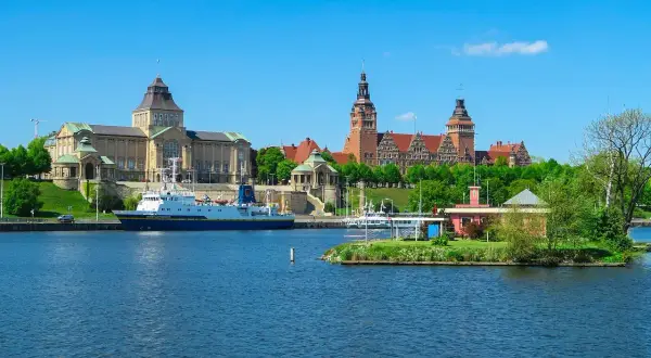 Widok na Odrę z imponującymi budynkami i statkiem. Odkryj atrakcje Szczecin i okolice!