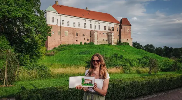 Kobieta trzyma szkic zamku, który przypomina miasto Ojca Mateusza.