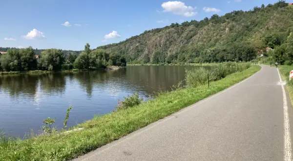 Malownicza ścieżka rowerowa w Czechach wzdłuż rzeki, zalesione wzgórza w tle. Idealne miejsce na aktywny wypoczynek.