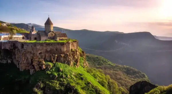 Klasztor Tatew na skale, jeden z cudów, które warto zobaczyć w Armenii. Majestatyczna budowla na tle doliny i zachodzącego słońca.