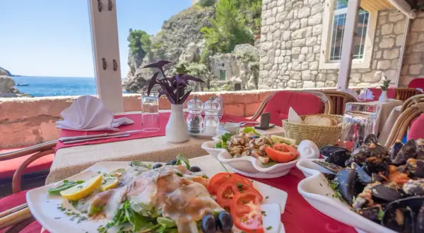 Pyszne owoce morza i ryby na stole w restauracji nad Adriatykiem. Idealne miejsce, by dowiedzieć się, co zjeść w Chorwacji.