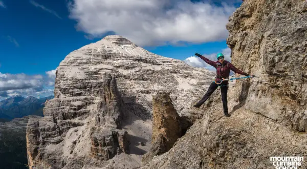 Kobieta na via ferrata w Alpach, pokonująca skalną ścieżkę. Widok na majestatyczne góry, idealne miejsce na via ferrata w Niemczech.