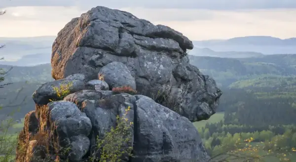 Gigantyczne formacje skalne, przypominające karłów, wznoszą się nad zieloną doliną. Błędne skały tworzą niezwykły krajobraz.