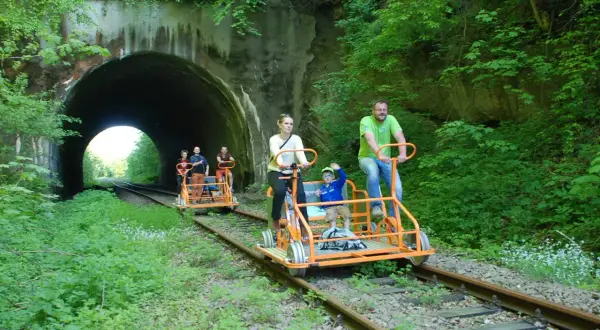 Rodzina na drezynach rowerowych w Uhercach, wjeżdża w tunel.