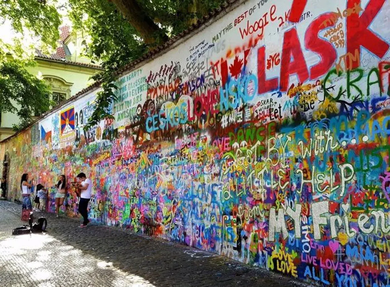 Kolorowa ściana Johna Lennona w Pradze, pokryta graffiti i cytatami, w tym "All You Need Is Love".