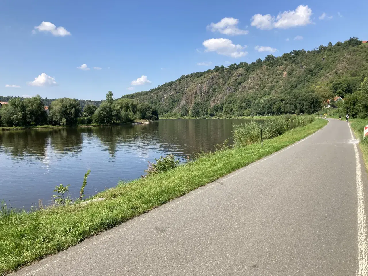 Malownicza ścieżka rowerowa w Czechach wzdłuż rzeki, zalesione wzgórza w tle. Idealne miejsce na aktywny wypoczynek.