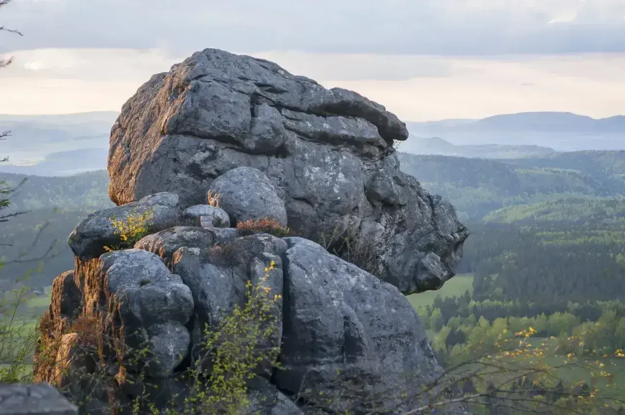 Gigantyczne formacje skalne, przypominające karłów, wznoszą się nad zieloną doliną. Błędne skały tworzą niezwykły krajobraz.