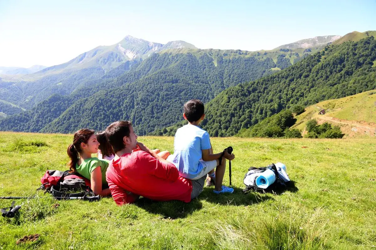 Rodzina odpoczywa na szlaku, podziwiając górski krajobraz. To idealna zakopane trasa na rodzinne wycieczki.