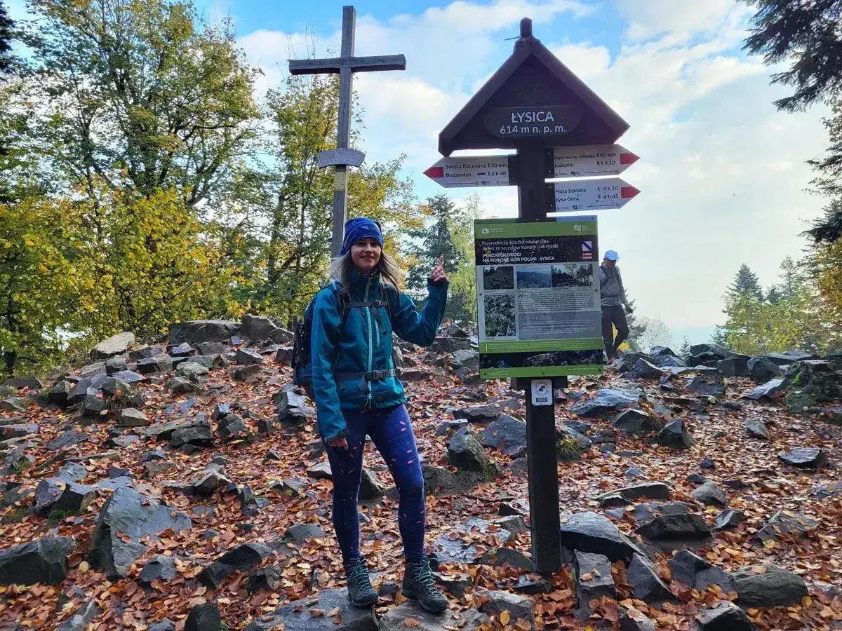 Uśmiechnięta turystka na szczycie Łysica (614 m n.p.m.) cieszy się jesiennym krajobrazem. Czas wejścia na szczyt minął!