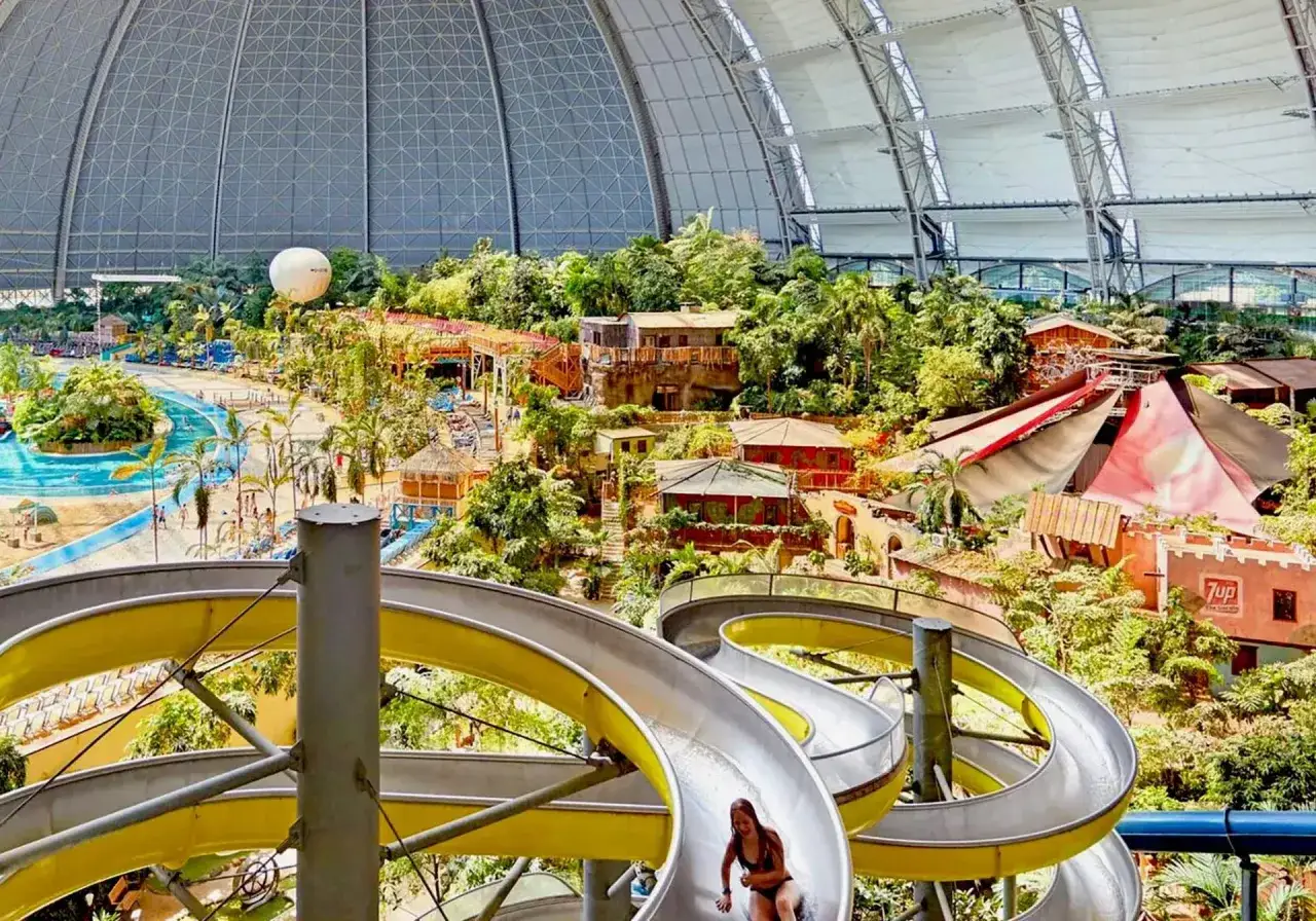 Wodny raj w Berlinie: basen Tropical Island z palmami, zjeżdżalniami i tropikalną roślinnością pod ogromną kopułą.