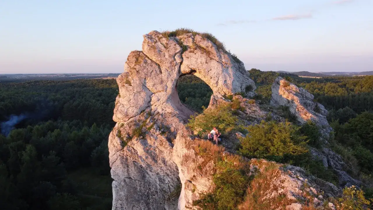 Maczuga Herkulesa na Jurze Krakowsko-Częstochowskiej, z parą siedzącą na skale.