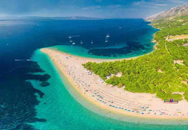 Zlatni Rat, jedna z najpiękniejszych plaż Europy, z turkusową wodą i sosnowym lasem.