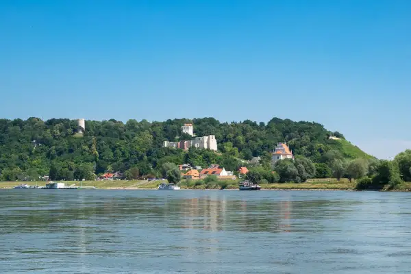 Widok na Wisłę i wzgórze z ruinami zamku, wieżą i kościołem. Kazimierz Dolny atrakcje zachwycają o każdej porze roku.