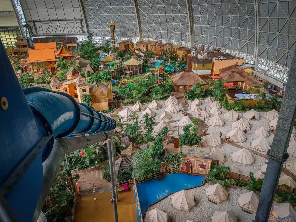 Wielki basen Tropical Island w Berlinie, z tropikalną wioską, zjeżdżalniami i namiotami na piasku.