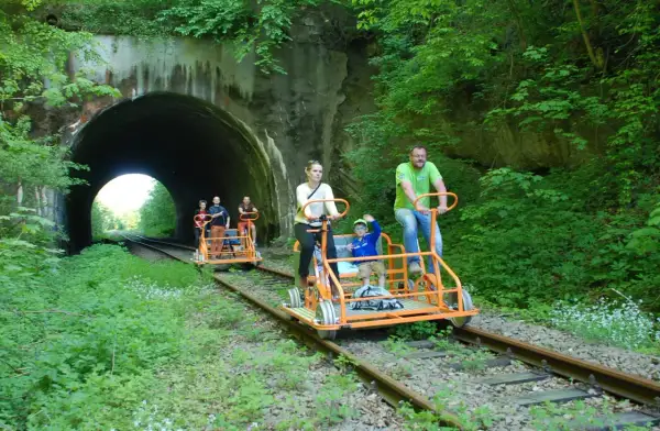Rodzina na drezynach rowerowych w Uhercach, wjeżdża w tunel.